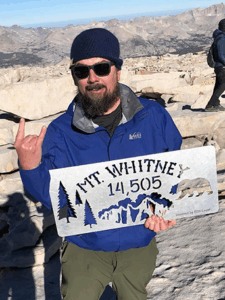 Picture of Tom Carlson holding Mt Whitney sign.